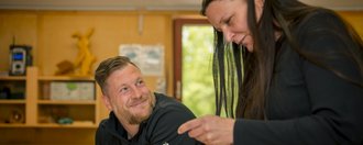 Haus Eckberg Zwei Personen stehen in der Werkstatt und unterhalten sich.