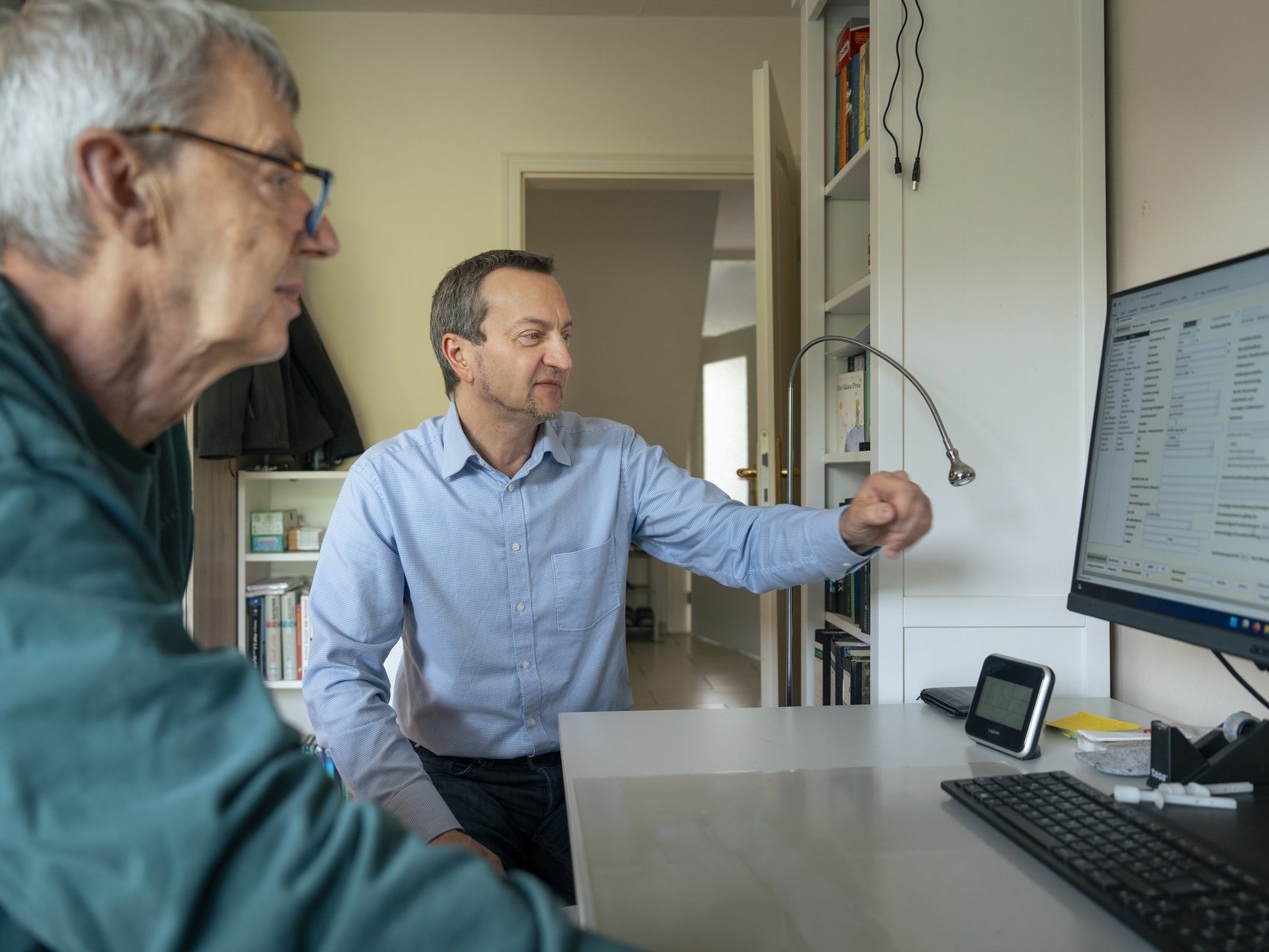 Ein therapeut berät einen mann bei seiner bewerbung am Computer