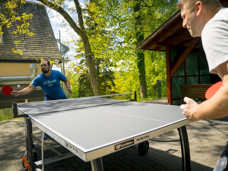 Zwei Personen spielen Tischtennis.